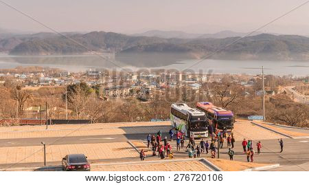 Yesan, South Korea; December, 23, 2018: Group Of Tourists Gathering In Front Of Tour Buses In Parkin