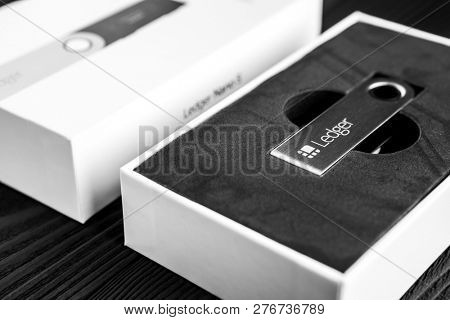 UKRAINE, ROVNO - ON DECEMBER 2: Ledger hardware wallet for cryptocurrency on a wood background