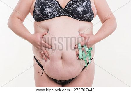 Overweight Woman Posing With Measure Tape On A White Background