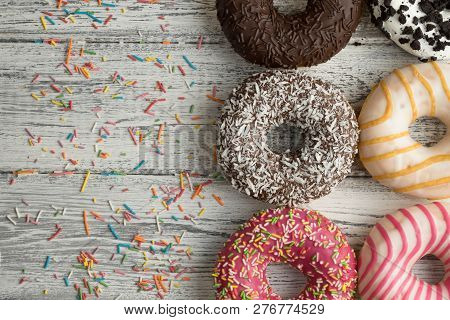Multi Colored Doughnuts On White Wooden Background