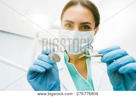 Selective Focus Of Female Stomatologist Holding Instuments In Hands
