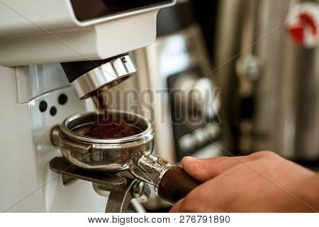 Maximising The Freshness. Coffee Grinder Grinding Roasted Beans Into Powder. Fresh Ground Coffee In 