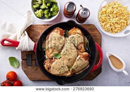 Cooked Chicken Breast Seared In A Cast Iron Skillet With Creamy Pan Sauce