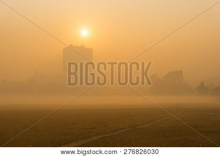 Beautiful Image Of Sunrise At Kolkata Maidan In A Foggy Winter Morning. Sunrises At The Horizon Abov