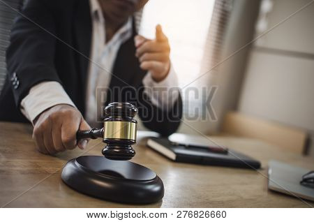 Justice Lawyer In Black Suit Pointing Finger And Knocking Wooden Judge Gavel With Documents On Workp