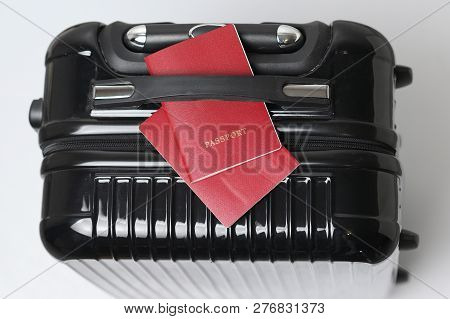 A Travel Bag And Two International Passports On It Under The Handle