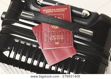 A Travel Bag And Two International Passports On It Under The Handle