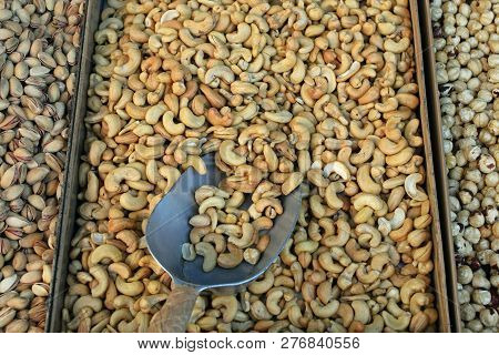 Cashews And Other Dried Nuts For Sale. Roasted Salty Snacks Food Background.