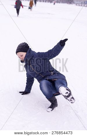 The Girl Slipped On Ice Covered With Snow, Falling And Injury In The Winter