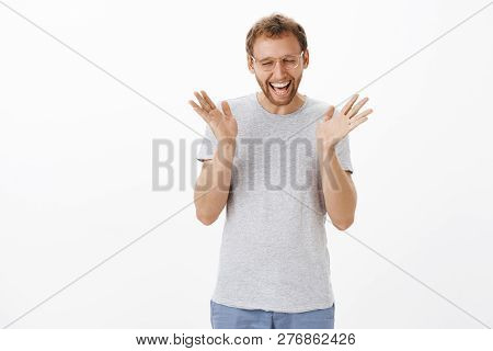 Indoor Shot Of Silly Happy Attractive Aduly European With Bristle Closing Eyes Triumphing And Celebr