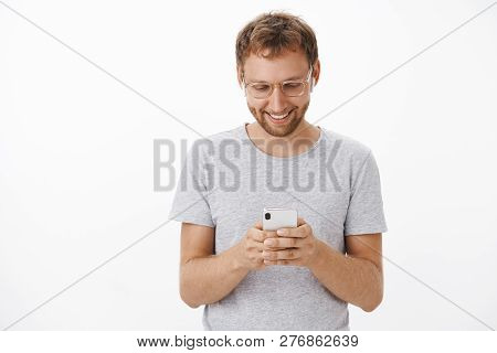 Texting With Girlfriend Being On Way Home. Relaxed And Joyful Handsome Aduly Male With Beard In Glas