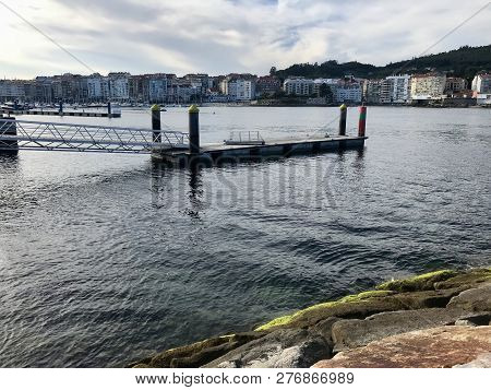 View Of The Harbour From Over Some Rocks On Galicia Spain