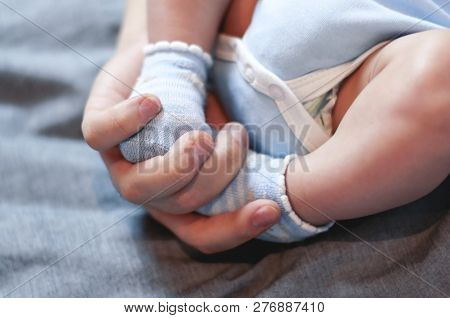 Dad Holds The Legs Of His Little Child. Selective Focus