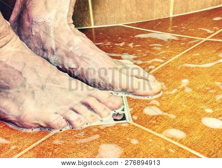 Couple Of Naked Feet In Shower. Detailed Foot Toes, Floor Tilles, Stainless Sink. Feet Washing In Ba