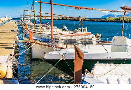 Boats Anchored At Coast On Wooden Yetty