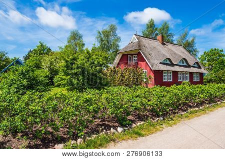 Building, Trees And Clouds In Wieck, Germany.