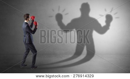 Businessman trying to fight with his unarmed shadow