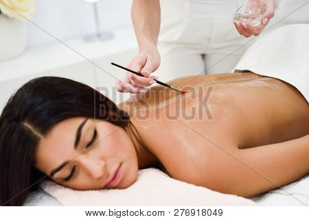 Woman Receiving Back Massage Treatment With Oil Brush In Spa Wellness Center