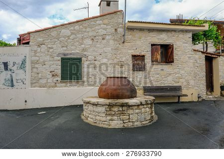Lania, Cyprus - May 13, 2018: Typrical Village Building With Pythari Jar Set Into An Old Well.