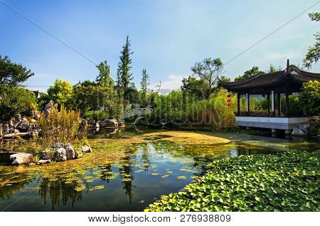A Chinese Building On A Small Lake Within The Luzhi Ancient Town Scenic Area On A Sunny Day In Wuzho