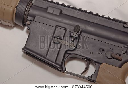 The Upper Of A Black And Brown 223 Caliber Ar-15 Rifle On A White Background Without An Inserted Mag