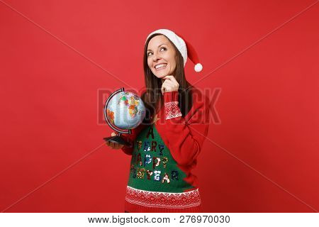 Pensive Young Santa Girl In Christmas Hat Looking Up Put Hand Prop Up On Chin Holding World Globe Is