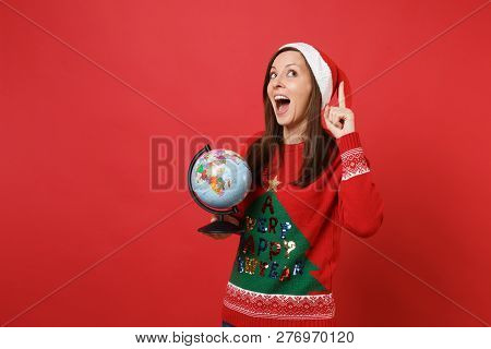 Pretty Santa Girl With Opened Mouth Pointing Index Finger Up With Great New Idea Hold World Globe Is