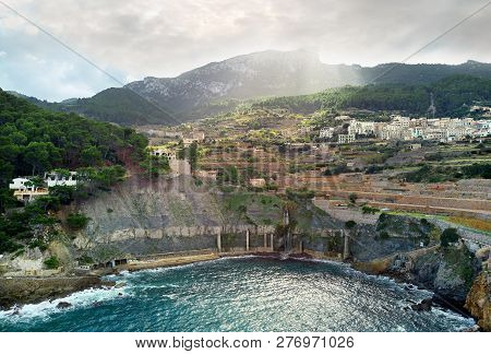 Aerial View Of Coastal Small Hillside Banyalbufar Town On West Coast Mallorca. Surrounded By Tramunt