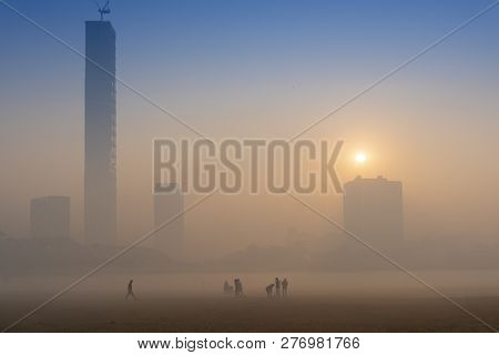 Beautiful Image Of Sunrise At Kolkata Maidan In A Foggy Winter Morning. Sunrises At The Horizon Abov