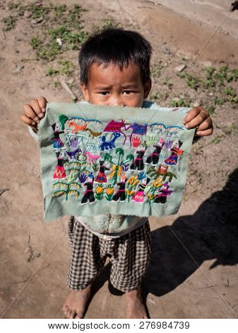 ban boe bak baw, laos - november 19, 2018: small boy selling handicrafts to tourists. growing away from luxury. residents of a mountain village.