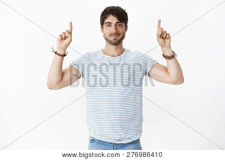 Handsome Young, Masculine Guy With Big Blue Eyes Smiling Friendly With Raised Hands Pointing Up Sugg