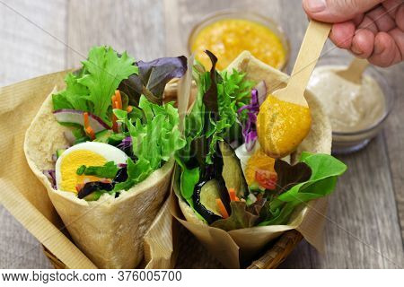 sabich: israeli pita sandwich with fried eggplant, hard boiled egg, israeli salad, amba and tahini souce

