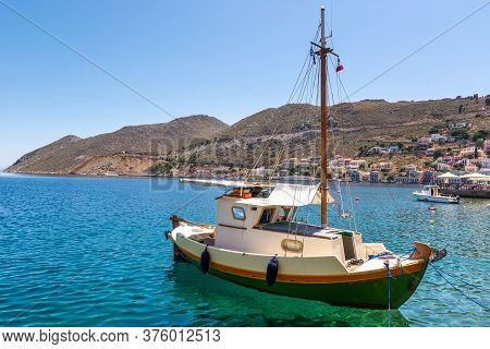 Boat Anchoring In Beautiful Symi Bay With Emerald Green Sea Water. Symi Island, Greece.