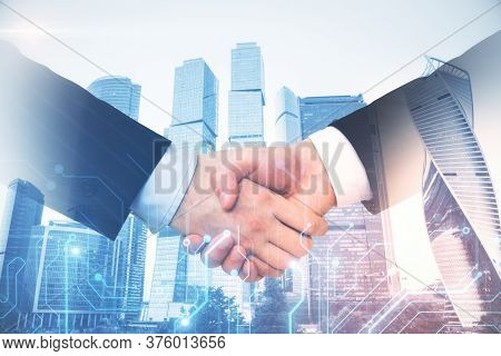 Business People Shaking Hands With Circuit Chip Interface On Blurry City Backround. Teamwork And Dea