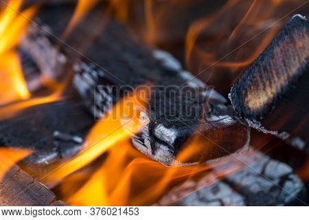 Flame Incinerates Firewood And Transforms It Ashes, Close Up, Shallow Depth Of Field. Blaze In A Lar
