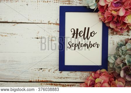 Hello September Card With Colorful Flowers Border Frame On Wooden Background