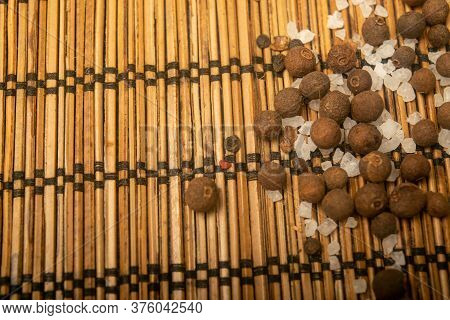Fragrant Black Pepper And Coarse Sea Salt In Bulk On A Reed Mat. Close Up.