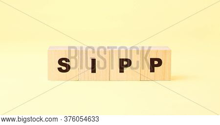 Black Letters Sipp Written On Small Wooden Cubes Against Bright Yellow Background At Light Close Vie