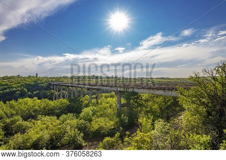 Ancient Old Bridge Over Southern Bug. Yuzhny Buh River Flow Through Green Trees. Nature Landscape