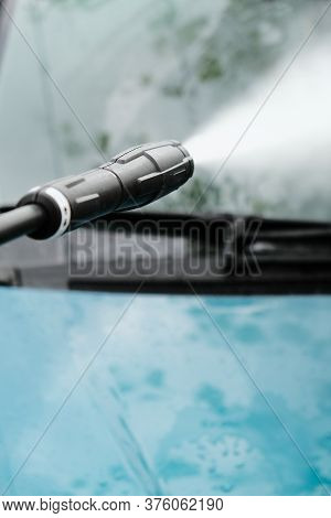 Car Wash At Home Alone. Car Wash High Pressure Close-up. A Man Washes A Green Car.
