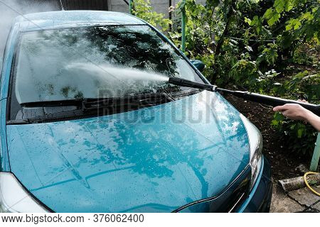 Car Wash At Home Alone. Car Wash High Pressure Close-up. A Man Washes A Green Car.