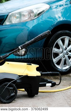 Car Wash At Home Alone. Car Wash High Pressure Close-up. A Man Washes A Green Car.