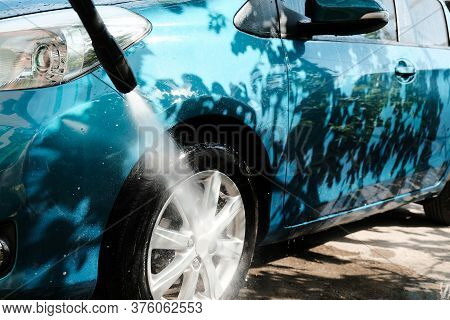 Car Wash At Home Alone. Car Wash High Pressure Close-up. A Man Washes A Green Car.