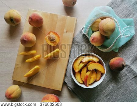 Flat Lay Juicy Sliced Peaches In A Plate, Whole Peaches And A Reusable Bag On Burlap