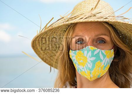 Funny Portrait Of Young Woman In Straw Hat On Tropical Sea Beach. New Rules To Wear Cloth Face Cover