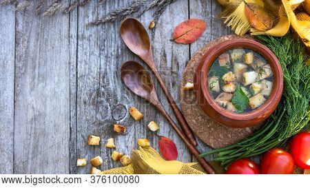 Autumn Soup With Croutons, Dill And Tomatoes On An Old Wooden Background With Fallen Leaves And A Ye
