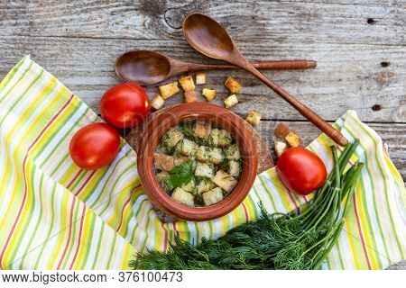 Delicious Broth With Croutons, Dill, Tomatoes On An Old Wooden Background. Lunch With Soup In A Clay