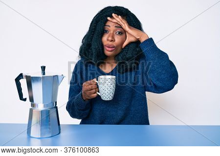 Beautiful african woman drinking a coffee from italian coffee maker stressed and frustrated with hand on head, surprised and angry face 