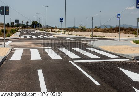 New Road Markings And Road Signs On Freshly Tarmacked Roads On Spanish Urbanisation