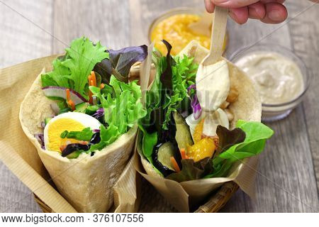 sabich: israeli pita sandwich with fried eggplant, hard boiled egg, israeli salad, amba and tahini sauce